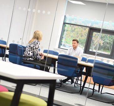 Image of two people in a meeting room